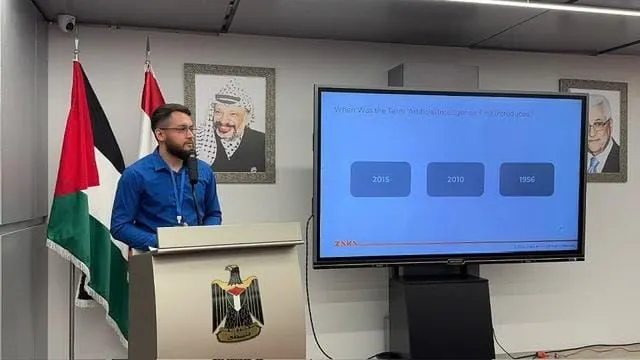 Presenting at a podium at the Embassy of Palestine in Beirut