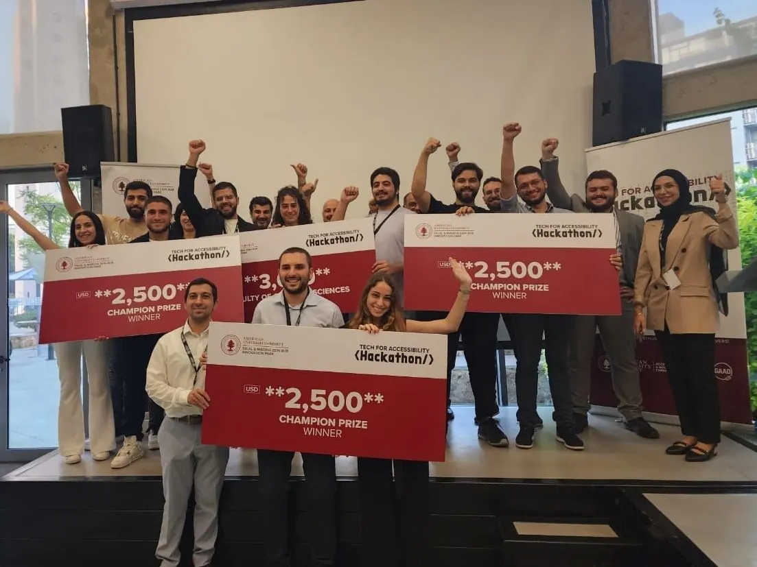 Winning teams on stage at AUB's Tech for Accessibility hackathon holding oversized prize cheques